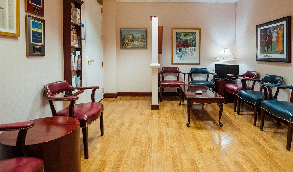Spacious waiting room with hardwood floors, comfortable seating, and framed artwork on walls