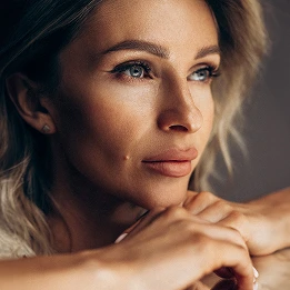 Mature woman with natural beauty and glowing skin looking at camera in soft lighting