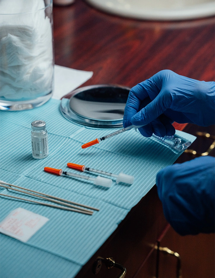 Laboratory technician in blue gloves preparing medical samples with test tubes and pipettes on sterile work surface