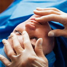 Surgeon performing rhinoplasty procedure on patient in operating room