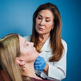 Female doctor in white coat examining patient's face for cosmetic treatment consultation - Upper Eyelid Surgery in Chicago, IL